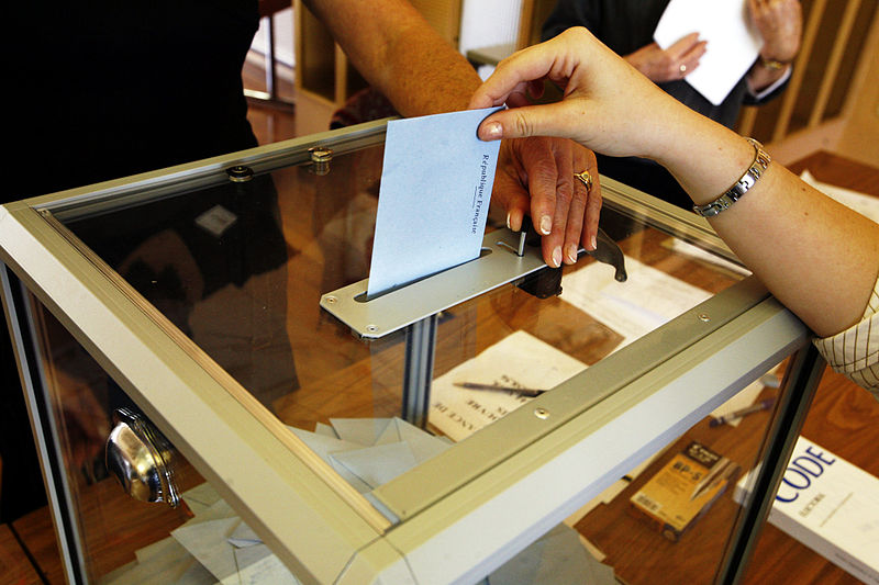 Voter dropping ballot into box