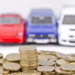 cars in front of gold coins